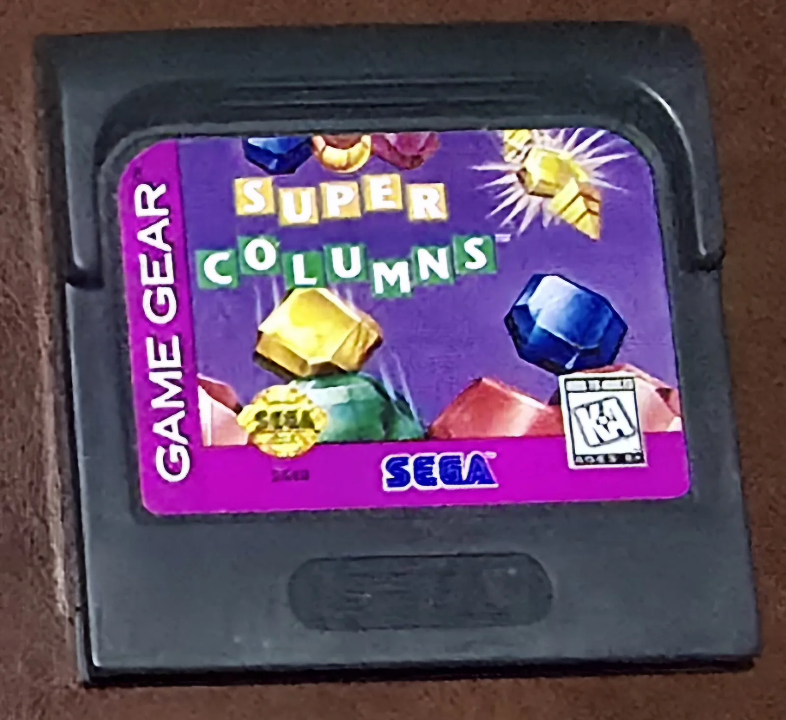 Front of an authentic Sega Game Gear Super Columns cartridge, the purple gem-matching label