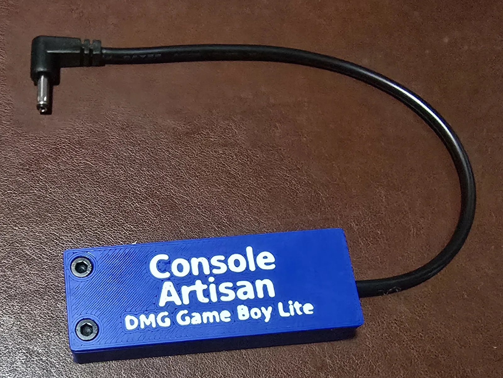 Front of the USB-C Game Boy DMG Lite power adapter, labeled Console Artisan DMG Game Boy Lite, with its right-angle barrel cable