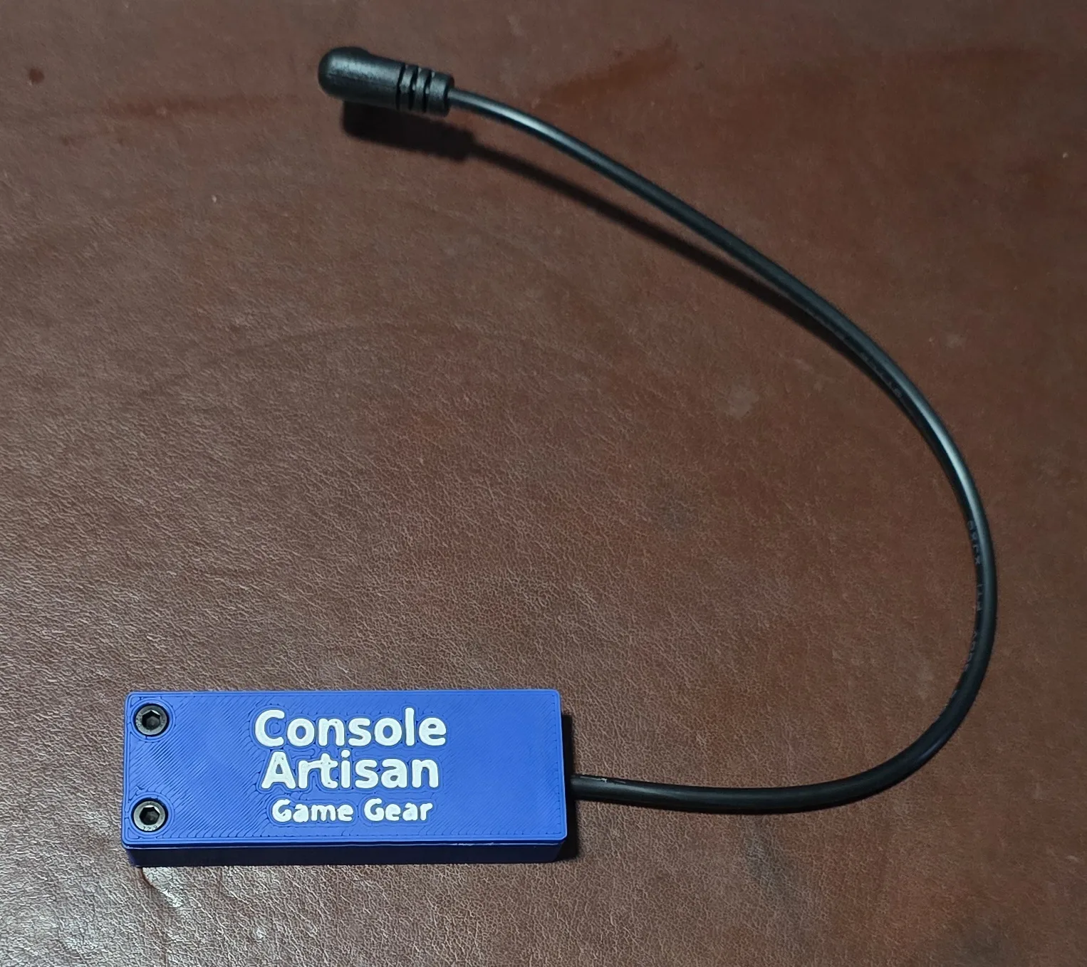 Front of the finished USB-C 9V Game Gear power adapter, labeled Console Artisan Game Gear, with its right-angle barrel cable