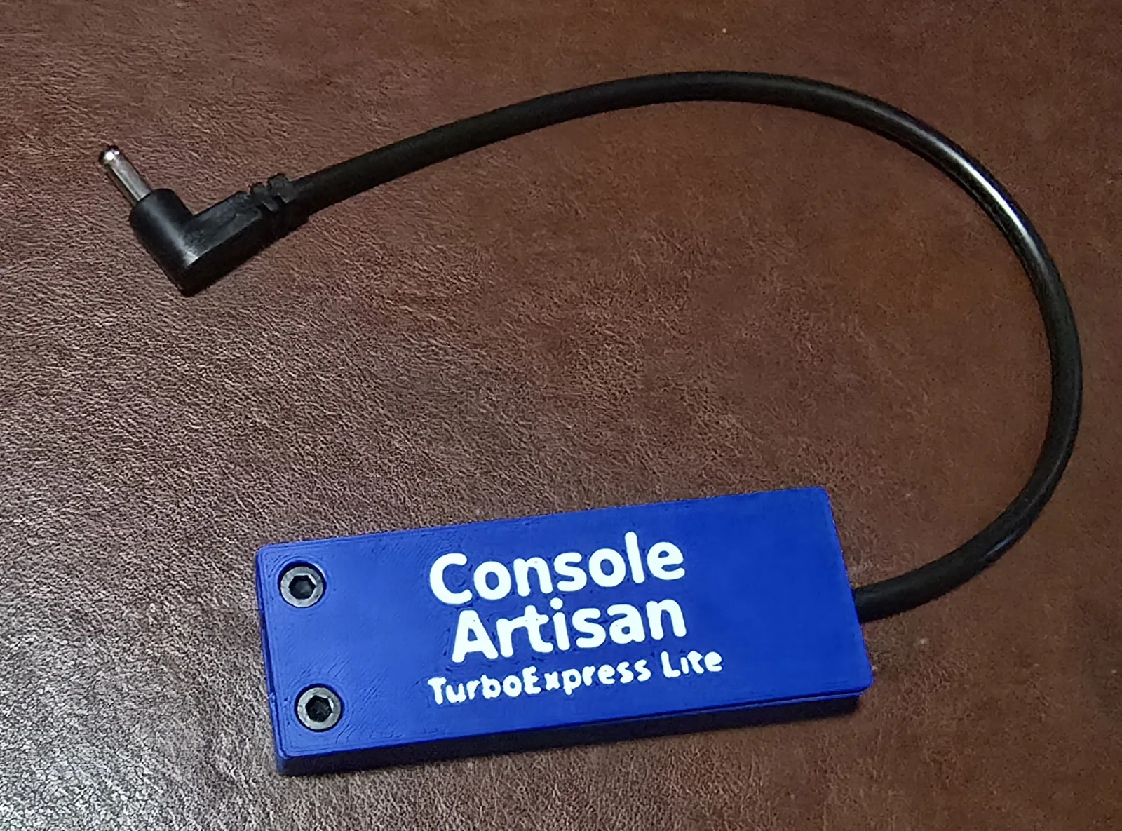 Front of the USB-C TurboExpress Lite power adapter, labeled Console Artisan TurboExpress Lite, with its right-angle barrel cable